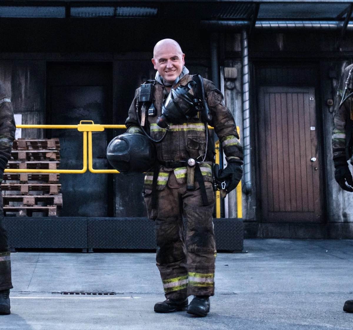 Denis O'Connell in full firefighter breathing apparatus, helmet in hand